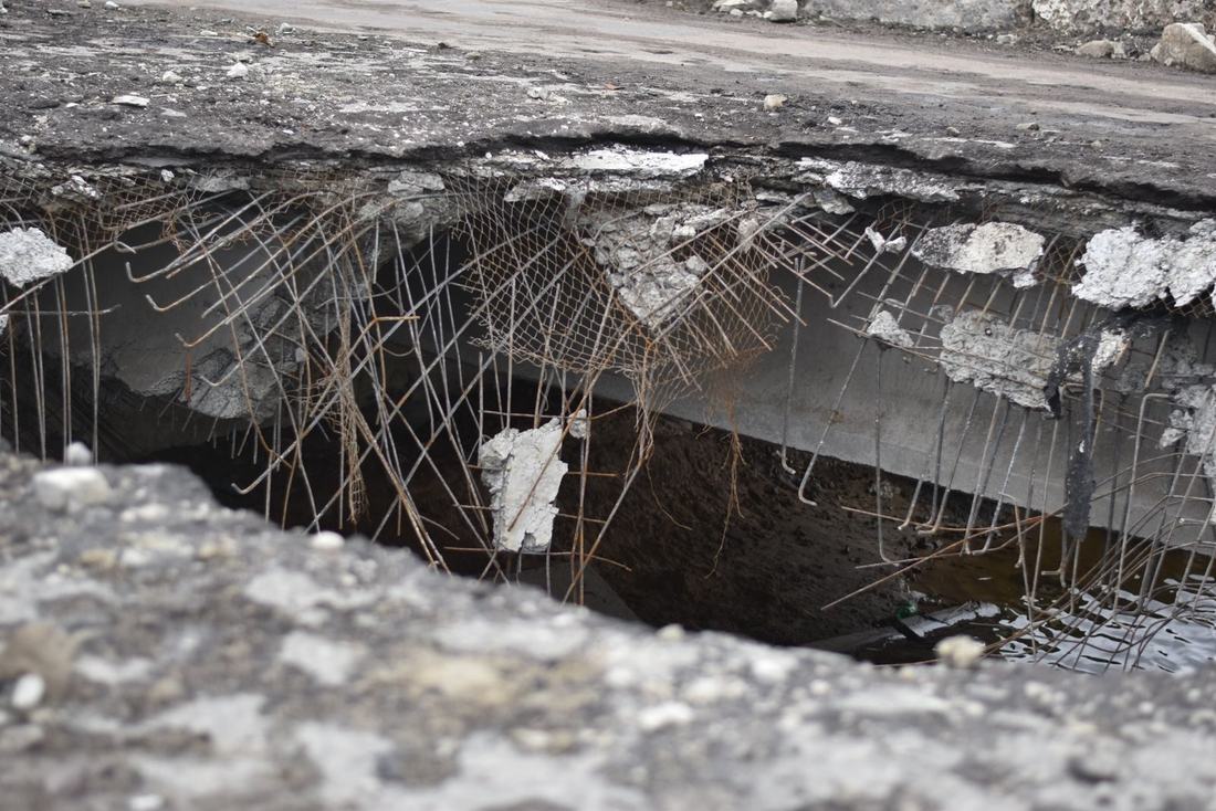 Wyrwa w asfalcie z popękaną nawierzchnią po zimie